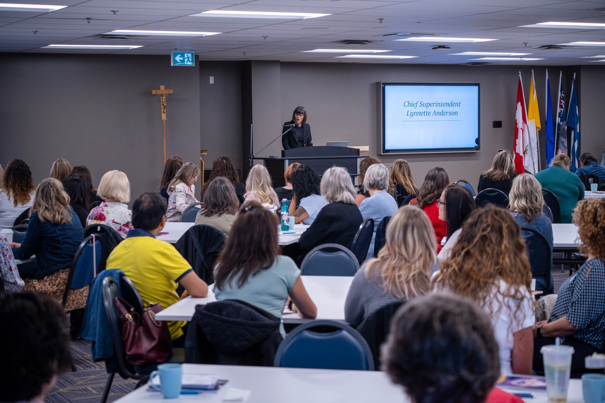 Lynnette Anderson speaking at the podium to a room full of school council members.